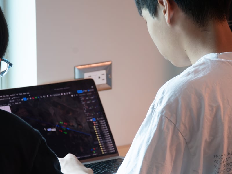 Students working together at a laptop in a workshop
