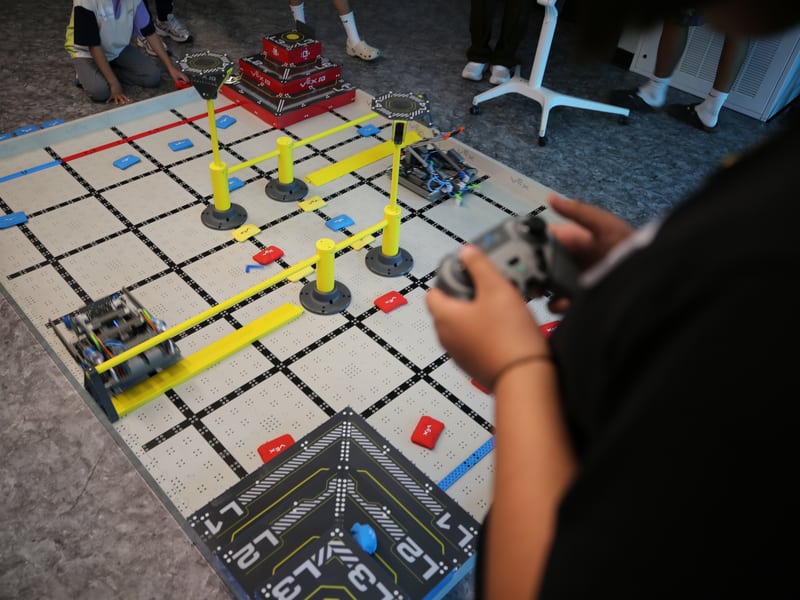 Students operating robots on a VEX competition field