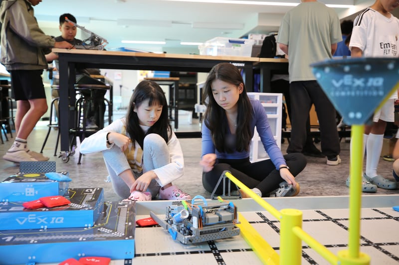 Two participants working together on a wheeled robot.